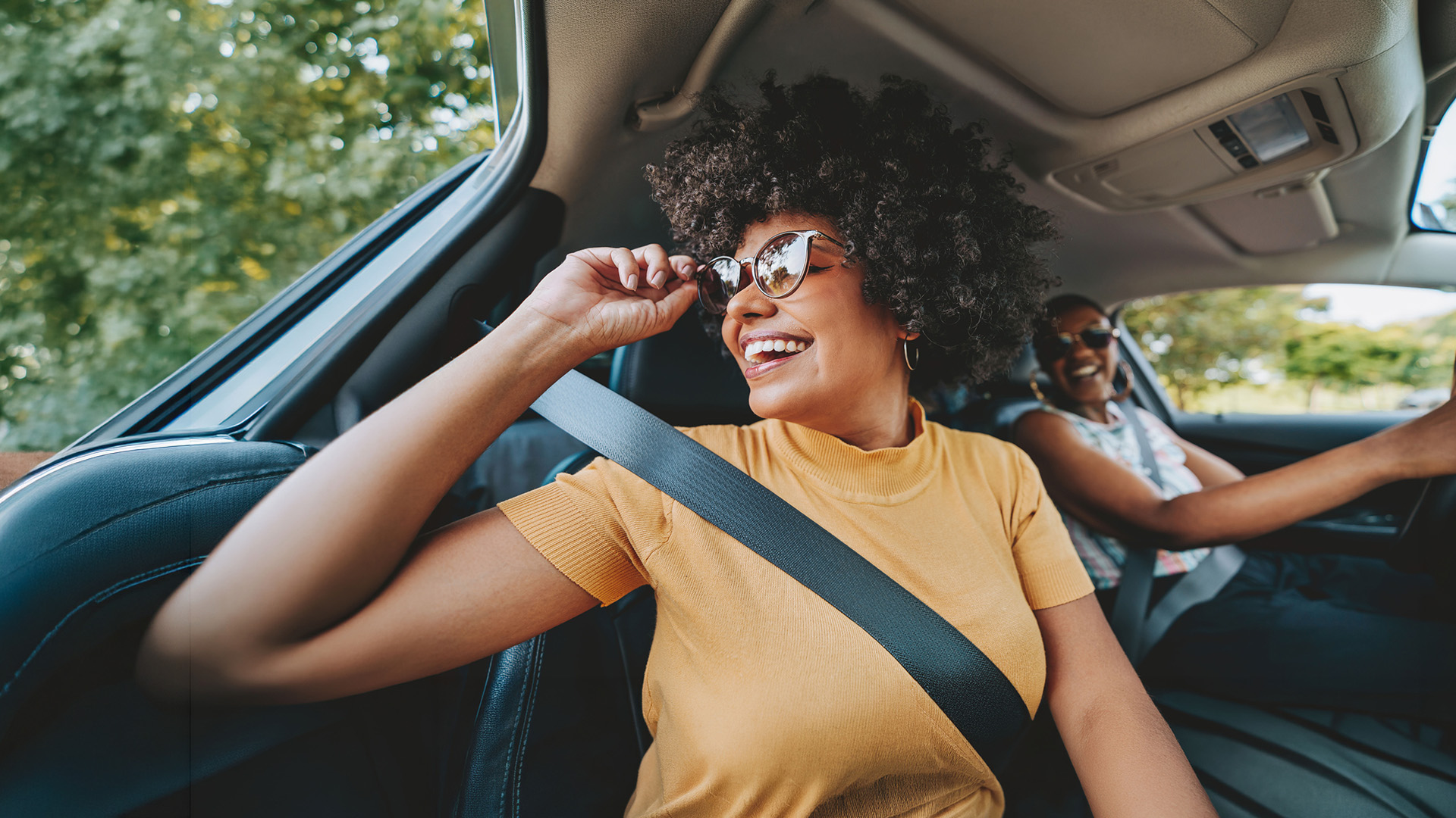 Twee lachende vrouwen in een auto